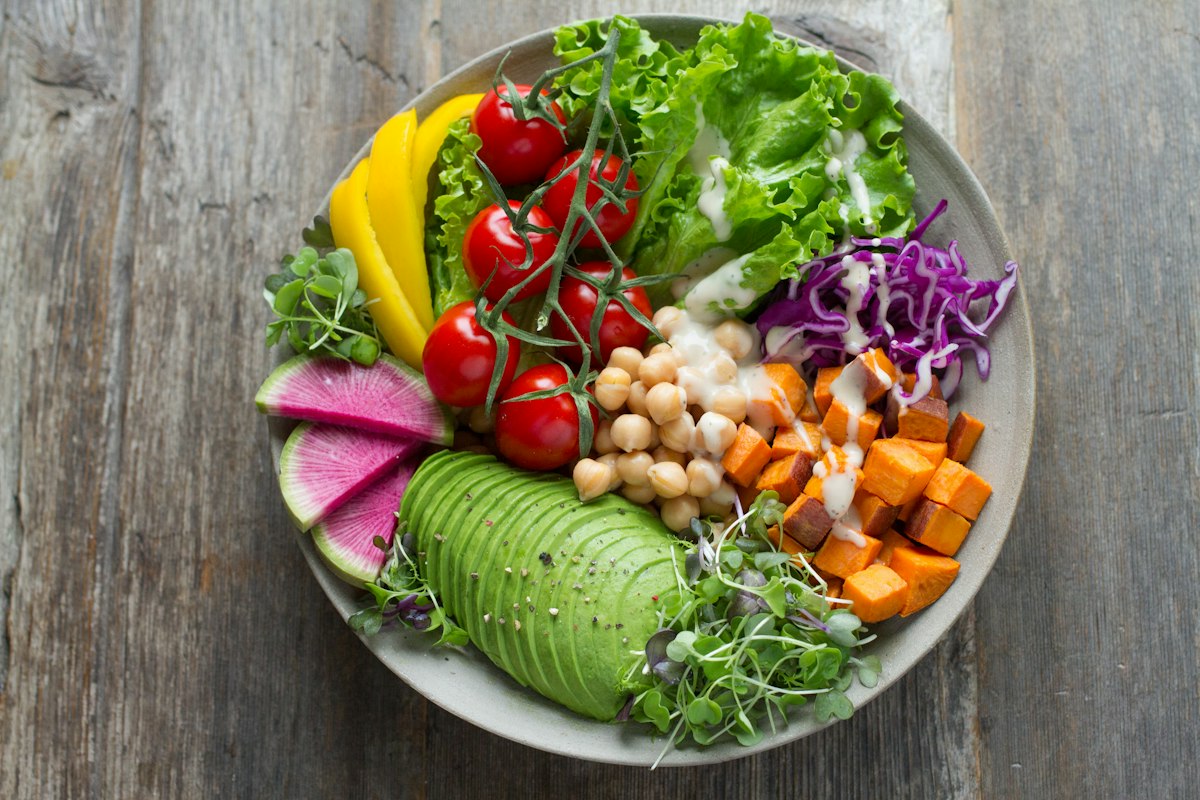 Variedad de verduras, frutas y granos integrales ricos en fibra sobre una mesa