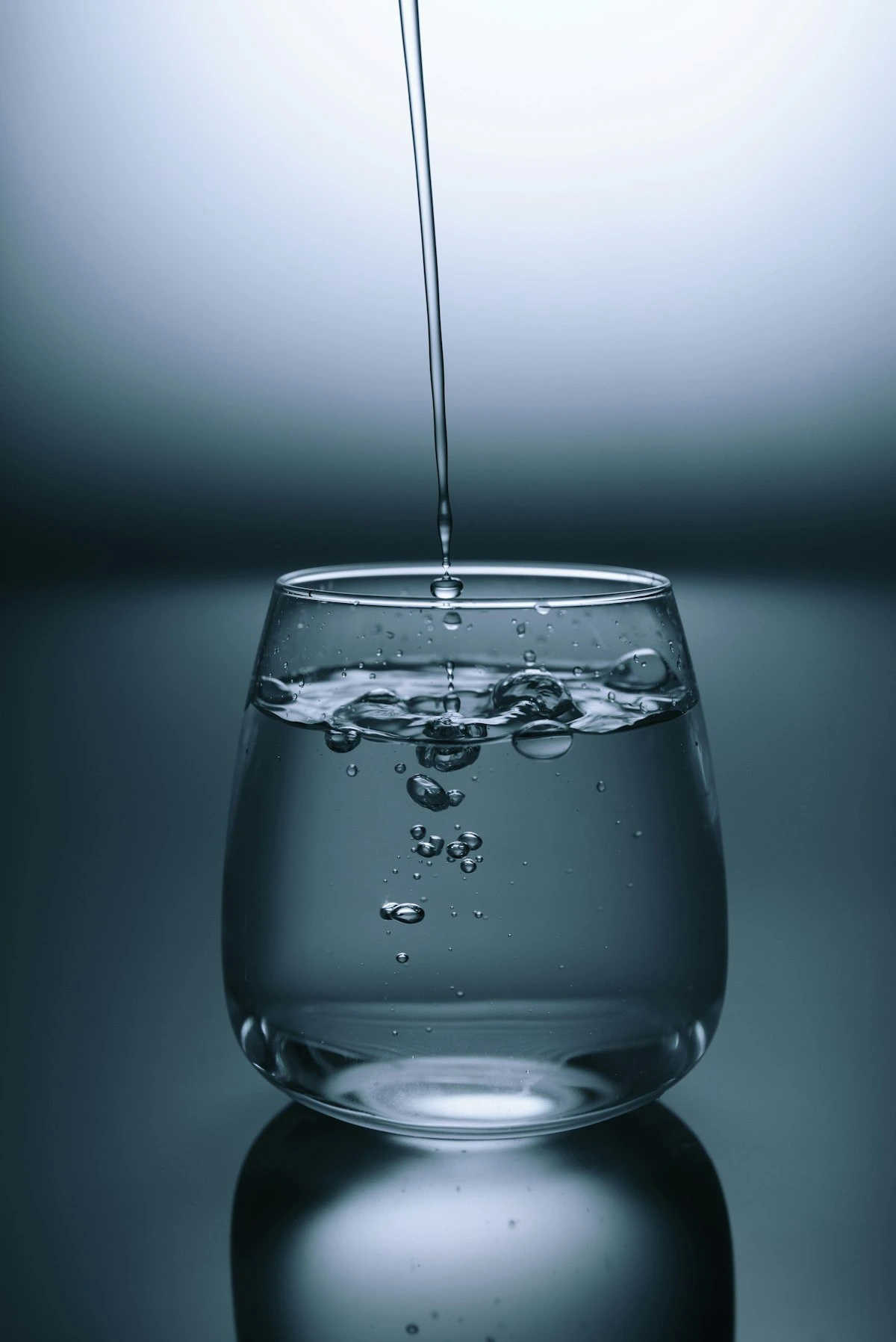 Vaso de agua siendo servido como recordatorio de mantenerse hidratado