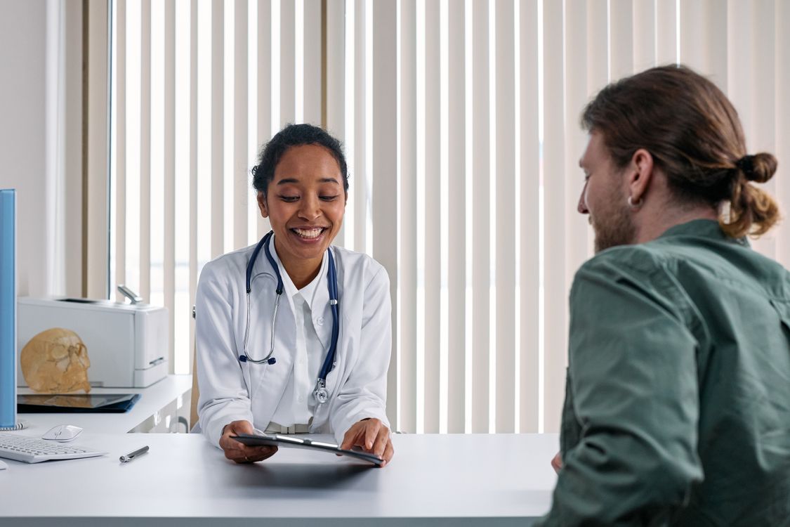 Médico conversando con paciente durante una consulta en el consultorio