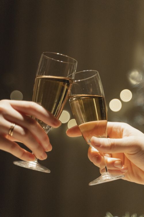 Manos brindando con copas de champagne en una celebración elegante