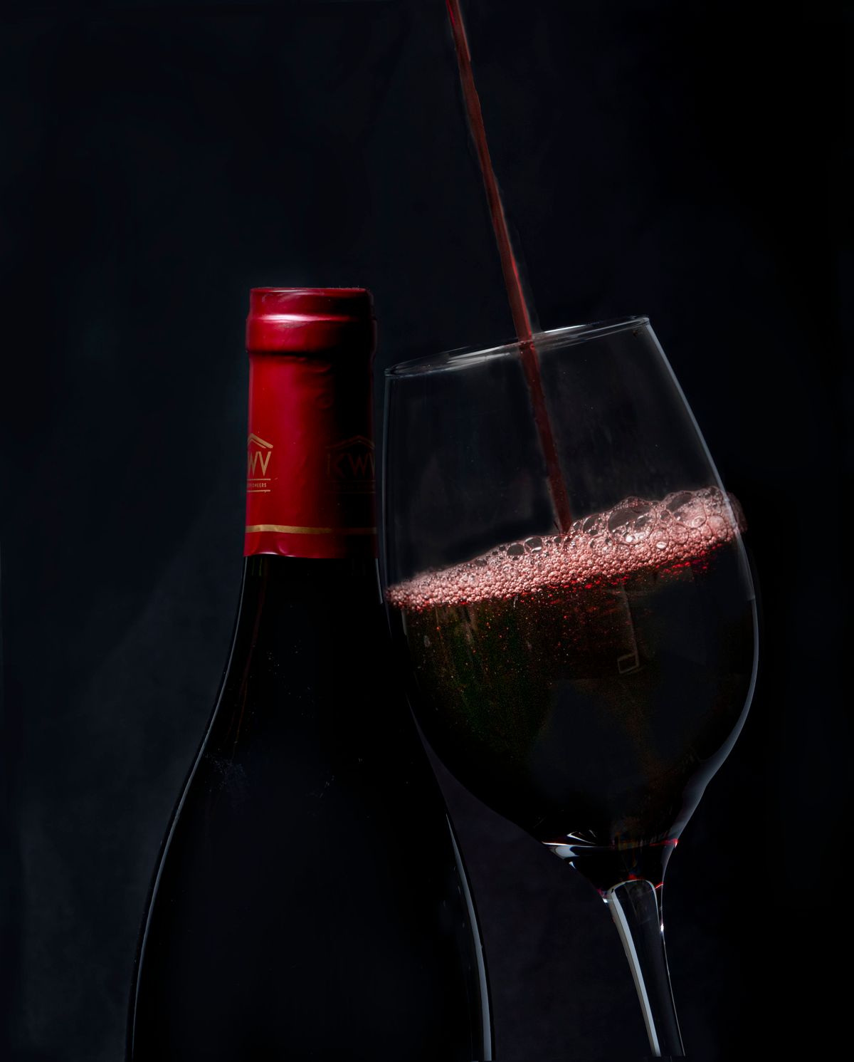 Copa de cristal con vino tinto siendo servido, ideal para ilustrar la conservación del vino
