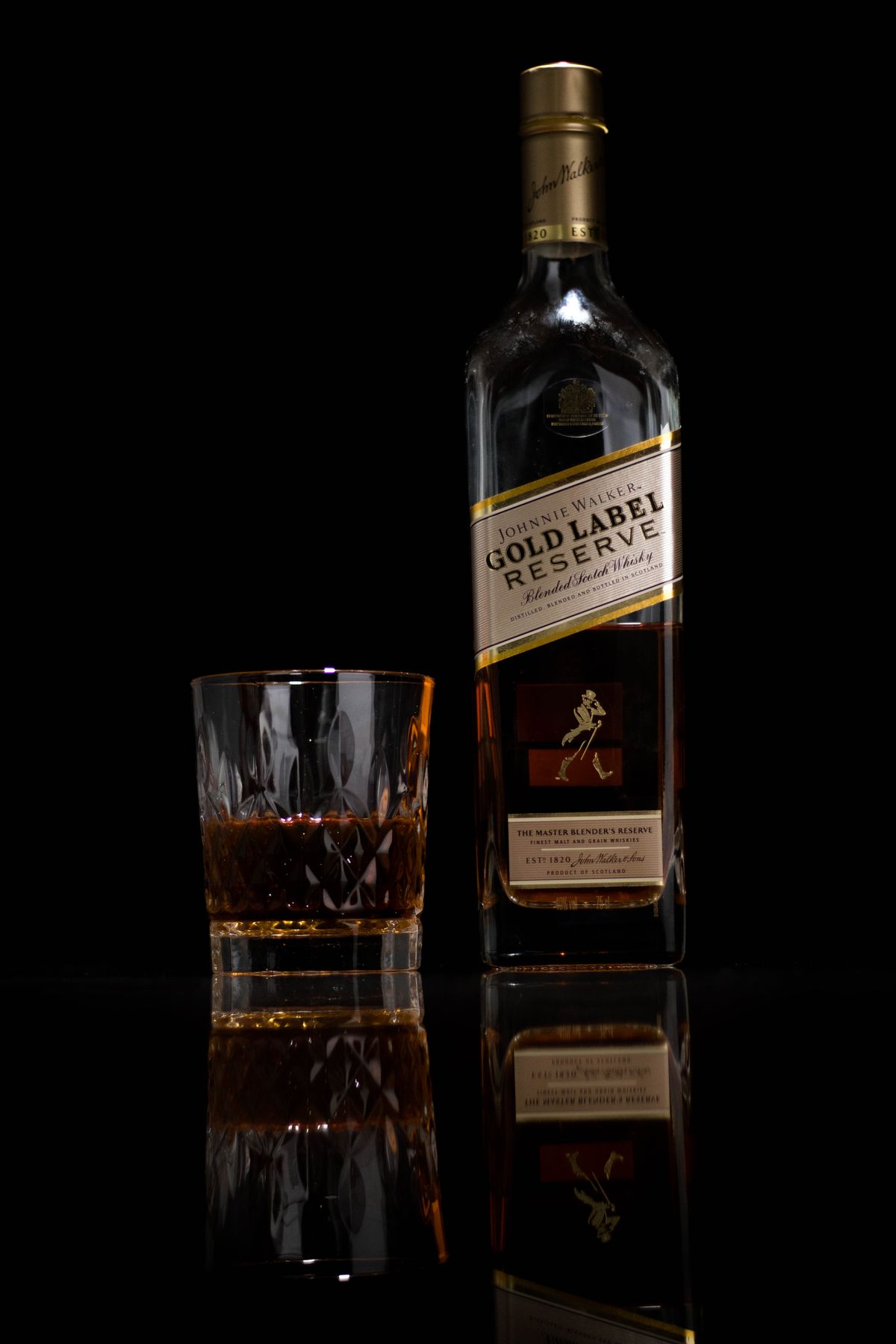 Vaso y botella de whisky sobre fondo oscuro que resaltan su color ambarino