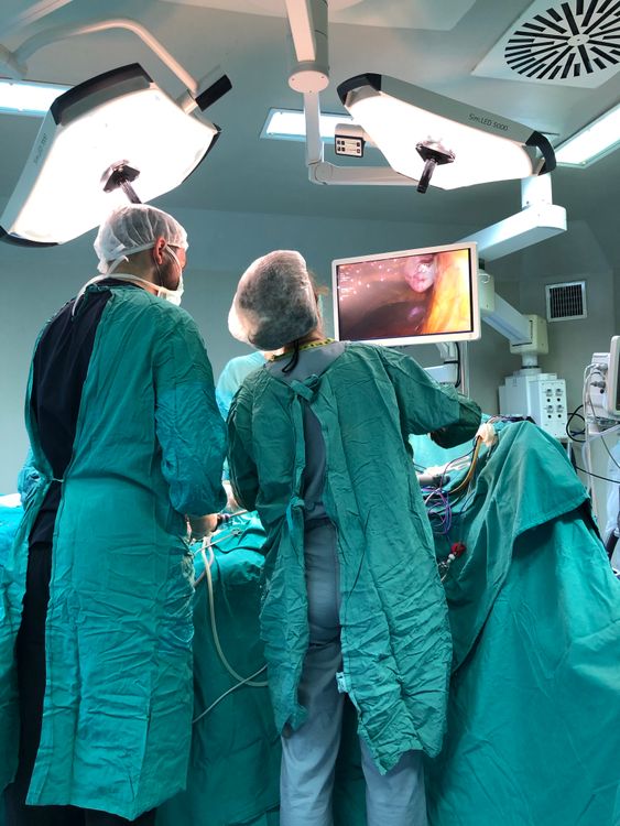 Dos cirujanos realizan una operación en un quirófano moderno con iluminación especializada
