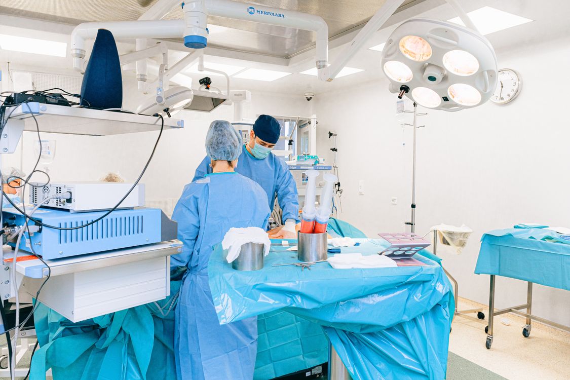 Profesionales médicos en quirófano con equipamiento quirúrgico especializado