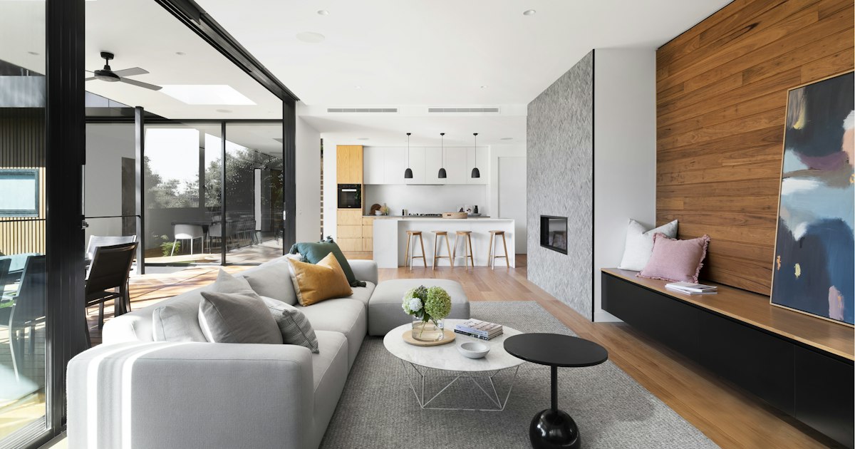 Interior luminoso de vivienda con ventanas de suelo a techo y vistas exteriores
