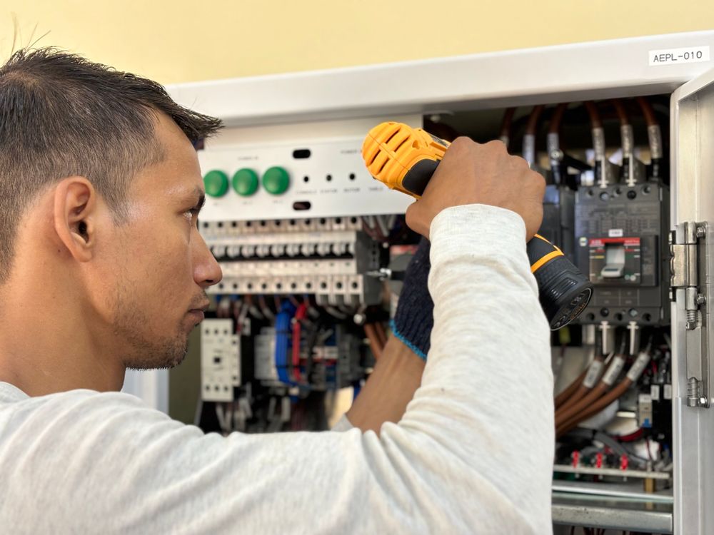 Profesional trabajando en la instalación de un cuadro eléctrico en interior