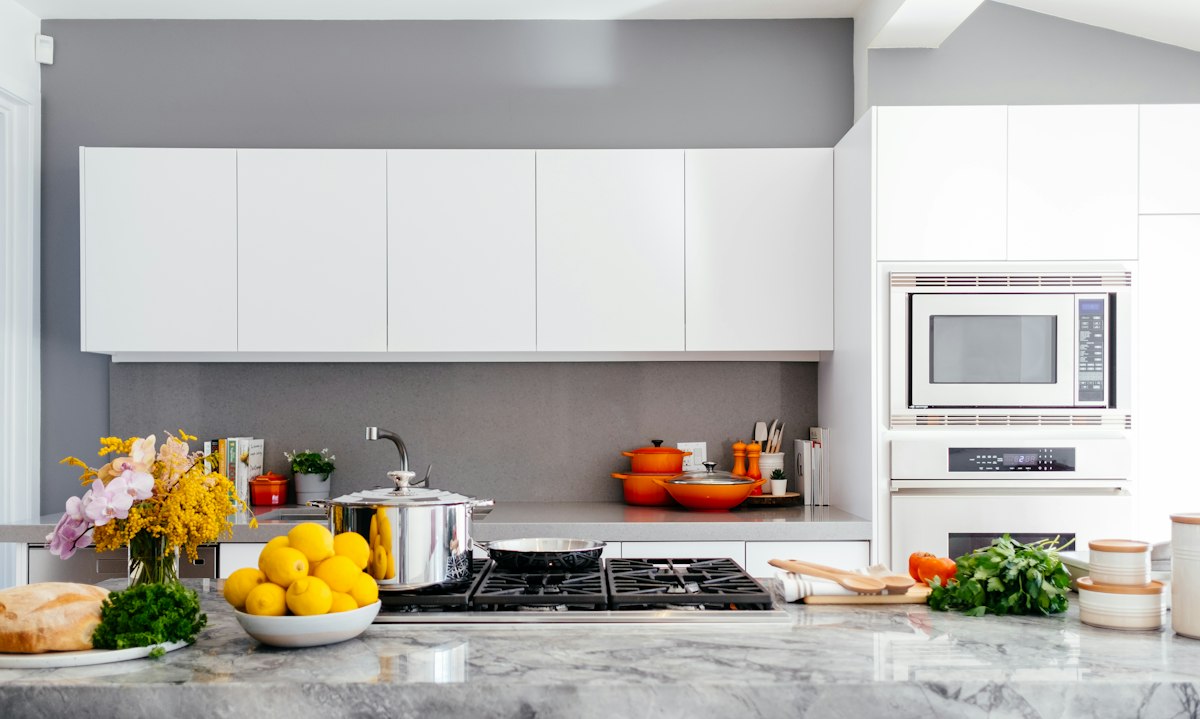 Cocina moderna reformada con muebles claros y encimera luminosa