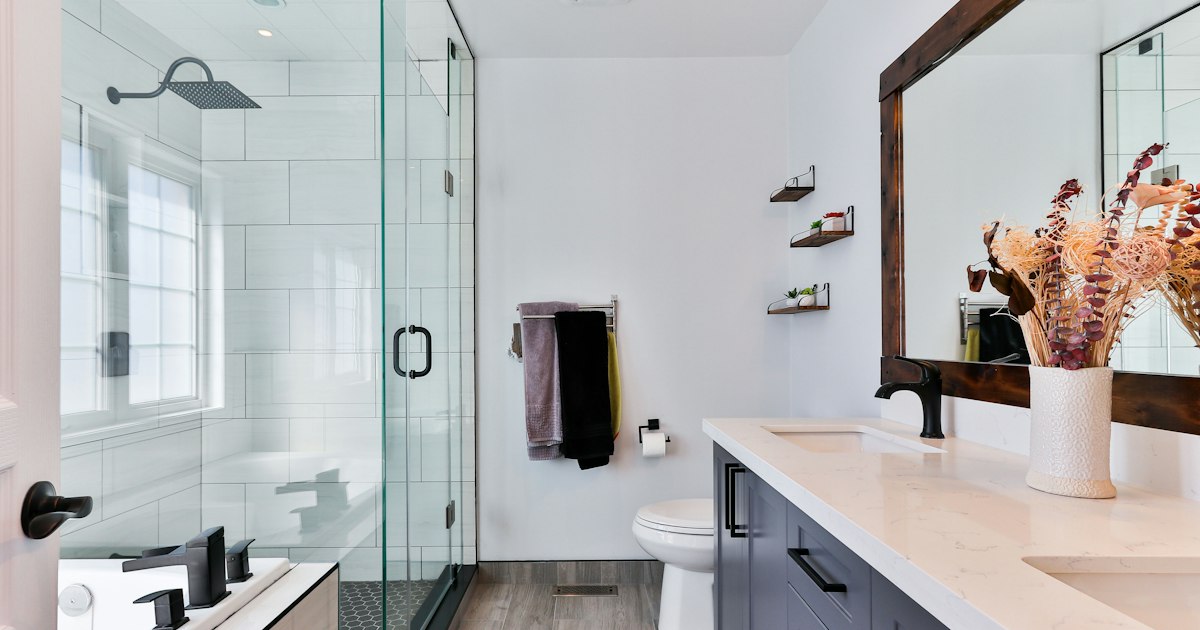 Baño reformado con ducha de obra, mampara de cristal y alicatado claro