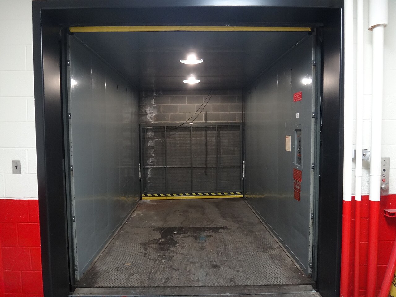 Interior de un montacargas industrial de carga con plataforma metálica