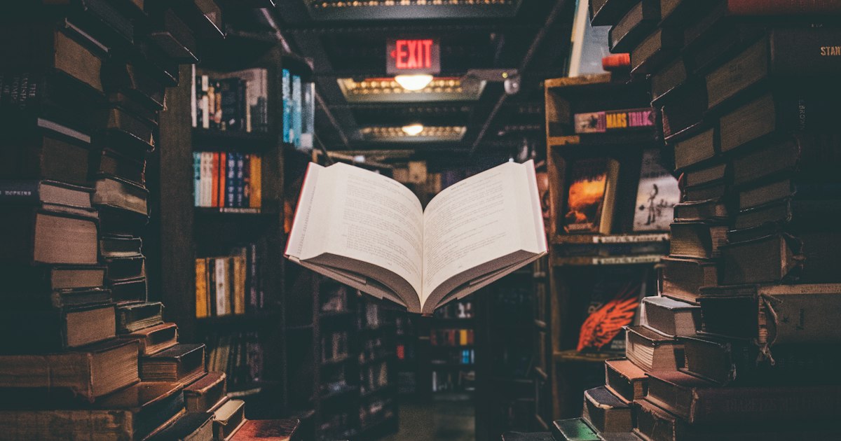 Colección de libros antiguos apilados mostrando lomos desgastados por el tiempo