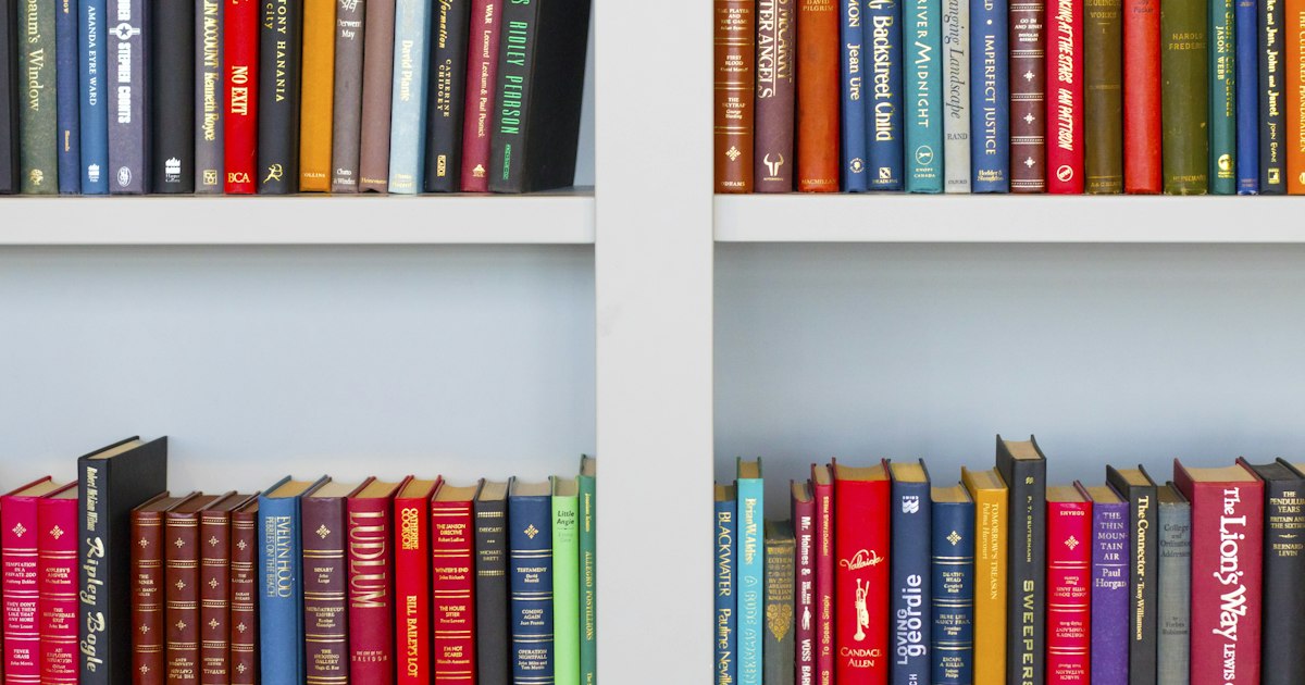 Estanterías altas repletas de libros antiguos en una biblioteca clásica