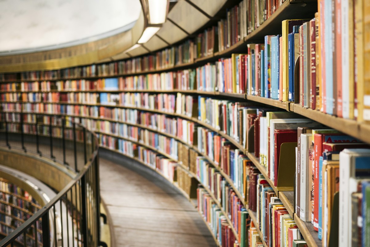 Colección de libros antiguos en estantería de biblioteca histórica