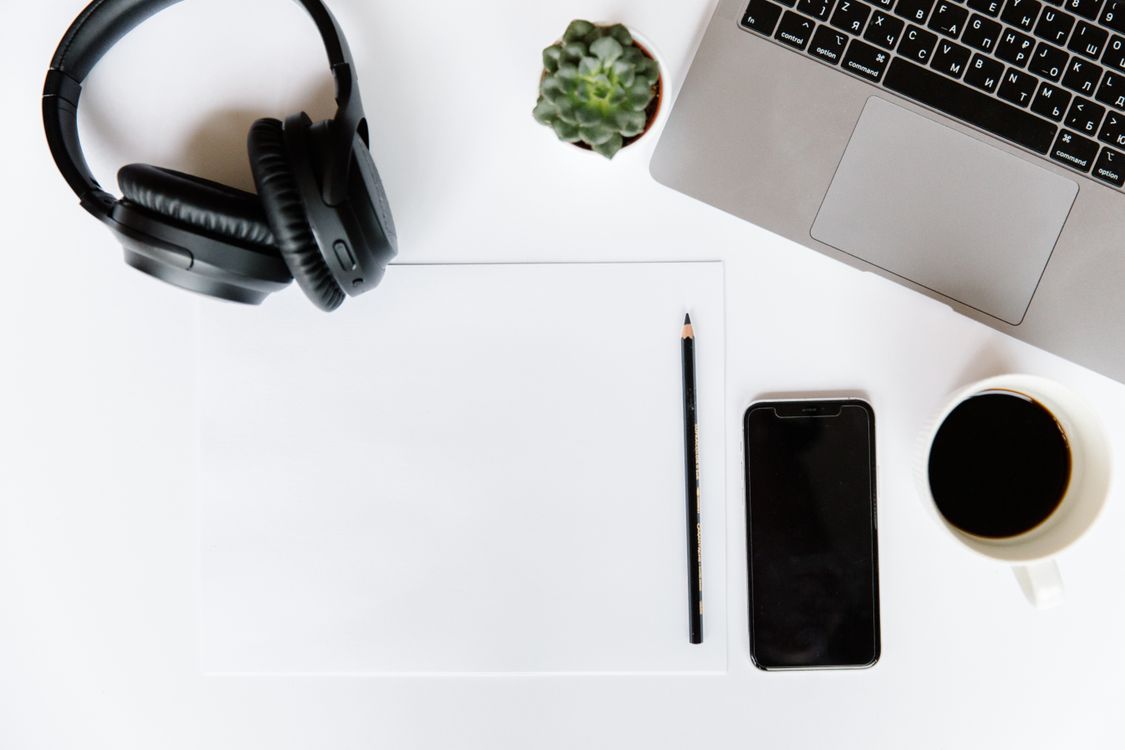 Minimalist creator workspace with a laptop, smartphone, and coffee