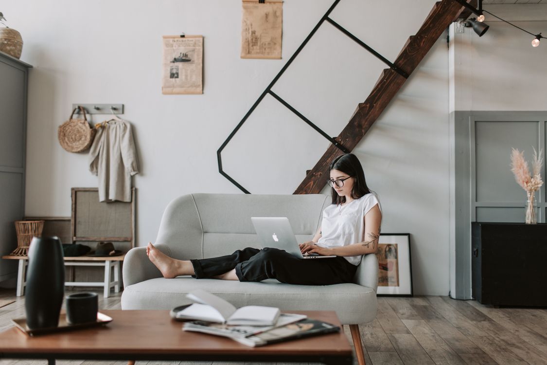 Content creator working on a laptop in a modern living room setting