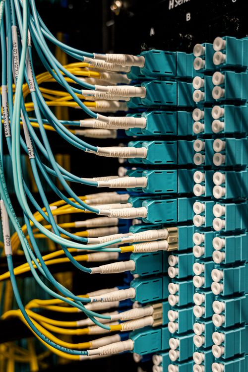 Técnico conectando cables a un panel de fibra óptica durante la instalación de internet