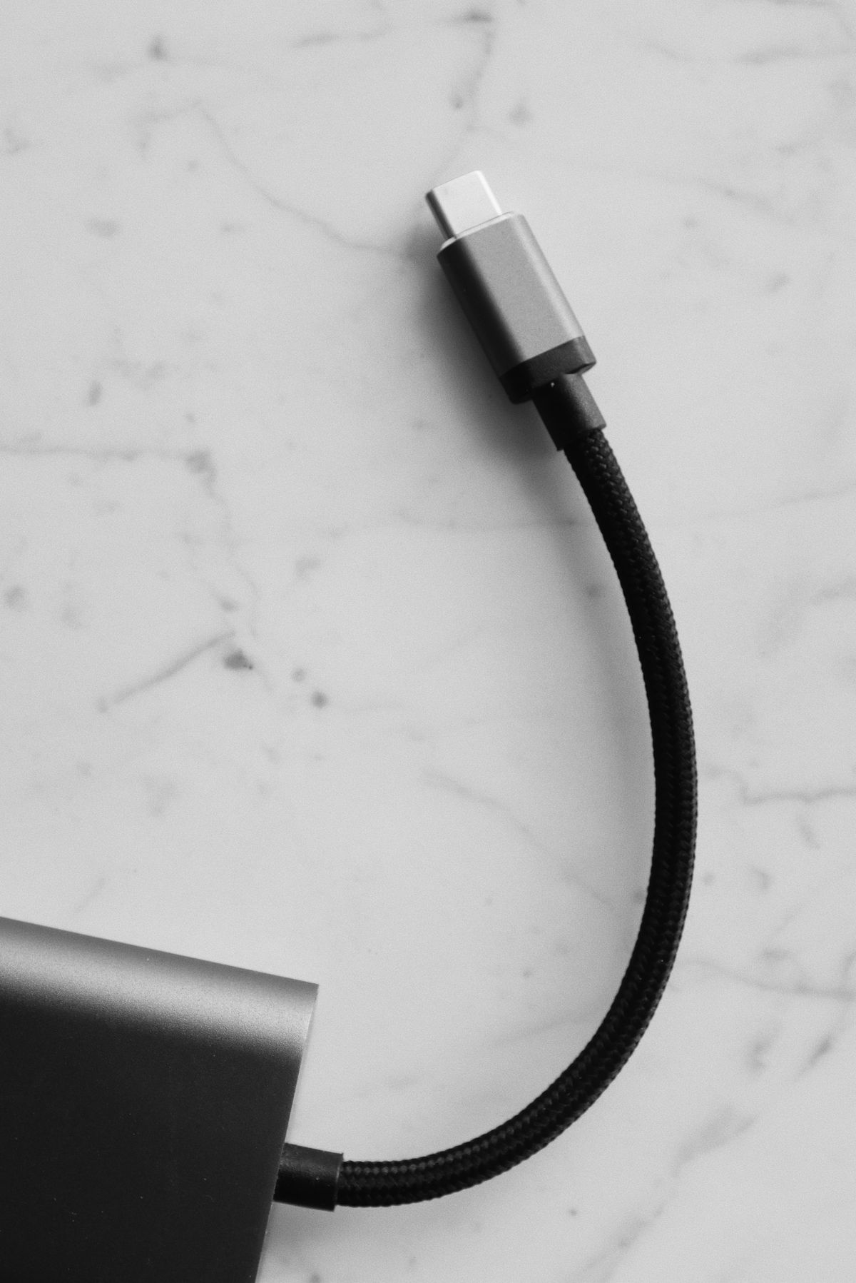 Cable USB-C negro sobre superficie clara, ideal para cargar dispositivos de vapeo