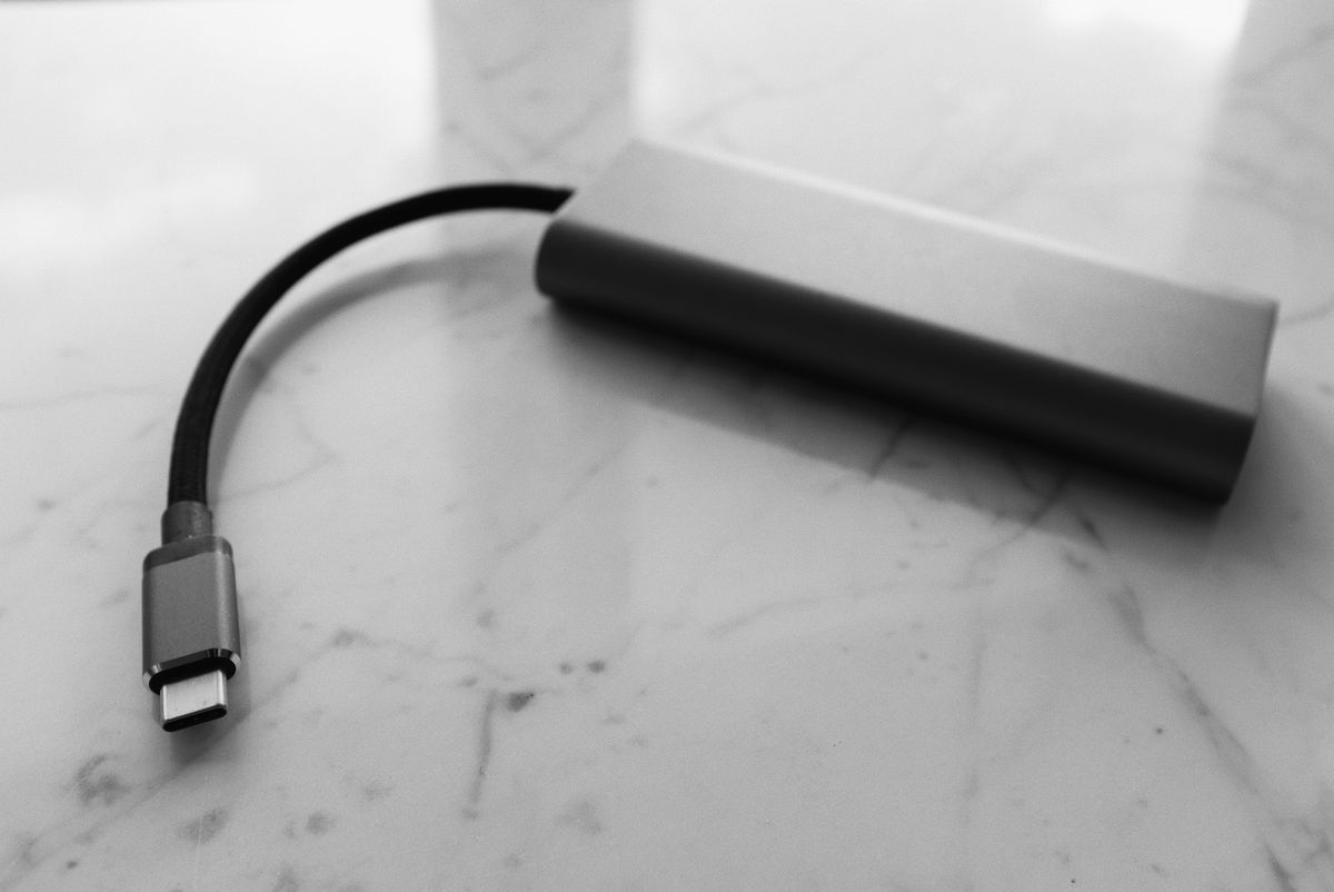 Batería externa portátil con cable USB-C sobre una mesa, lista para cargar un dispositivo de vapeo de forma segura
