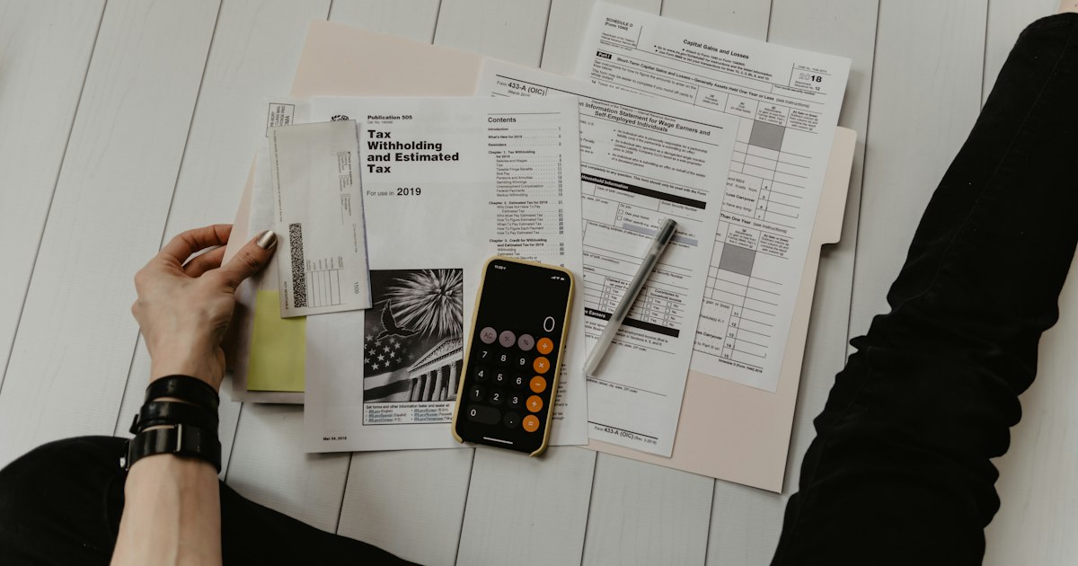 Calculadora e documentos financeiros representando controle de orçamento pessoal
