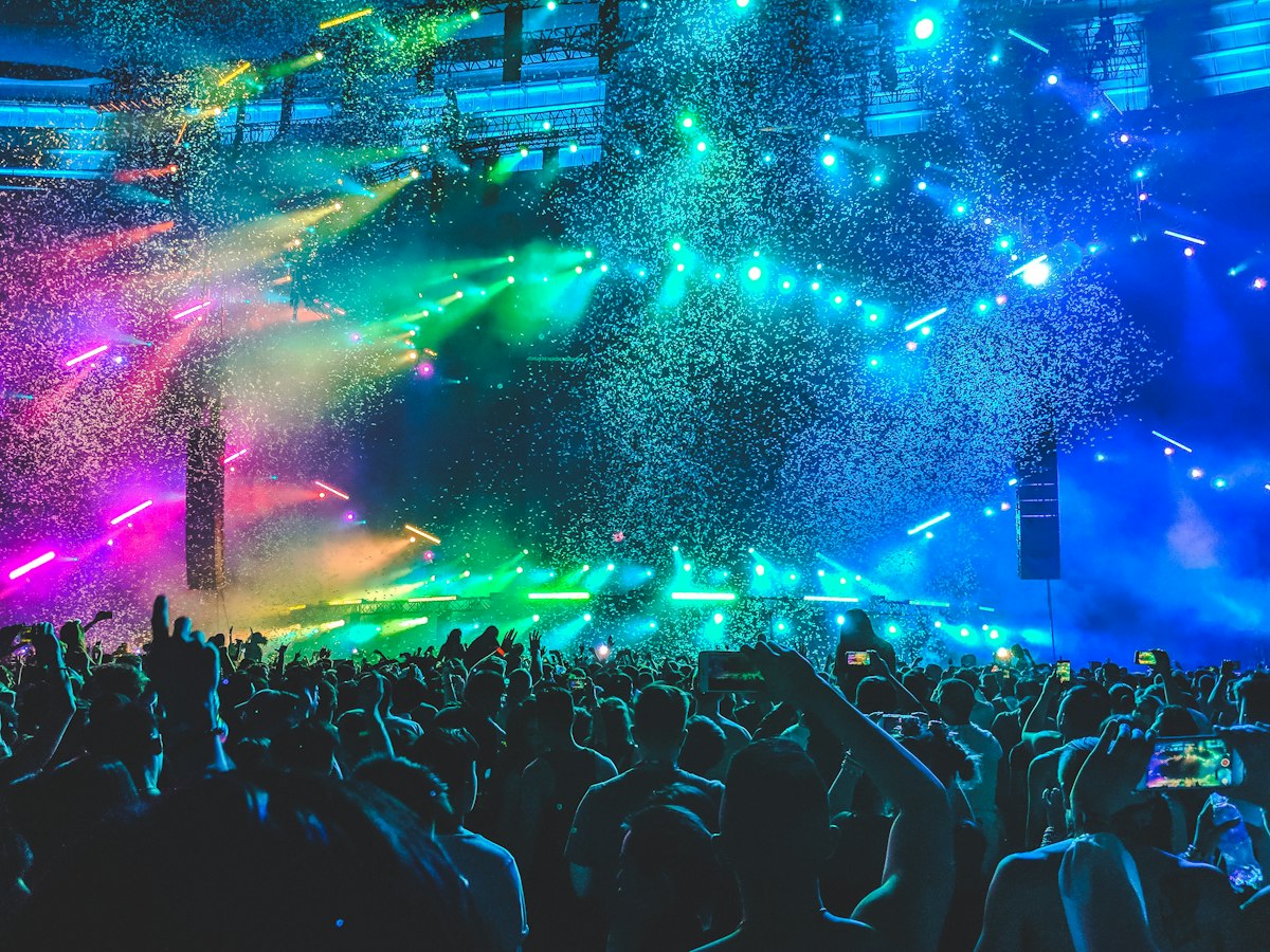 A crowd dancing under stage lights at a celebration