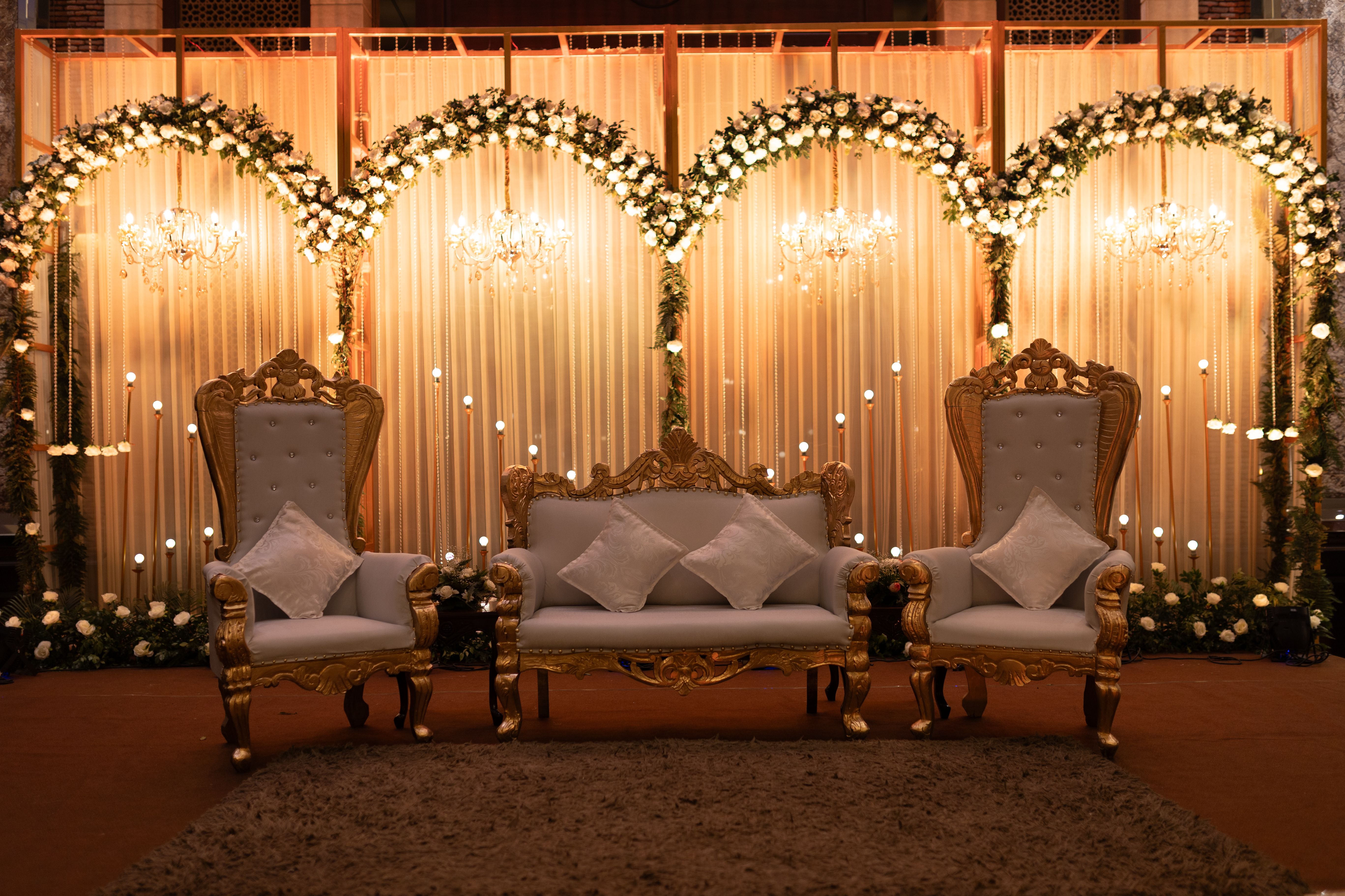 Elegant wedding stage with ornate chairs and warm ambient lighting