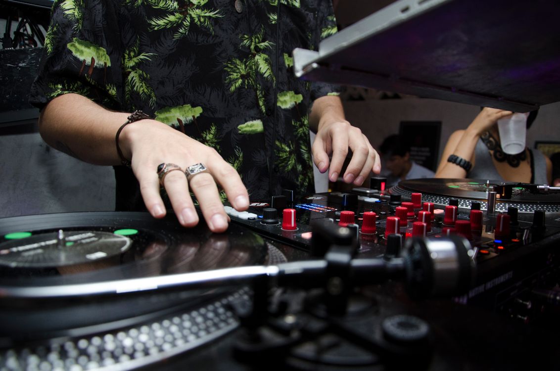 DJ mixing music at a wedding with hands on the mixer and controller.