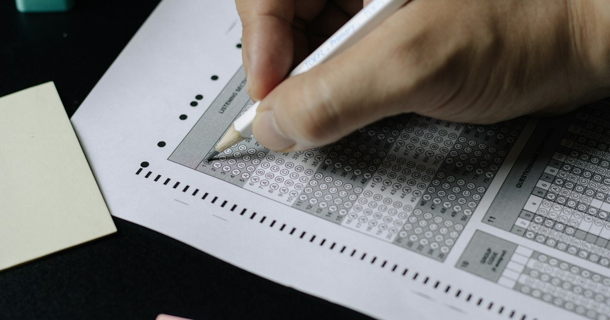 Hands reviewing printed documents and paperwork on a desk while organizing an application