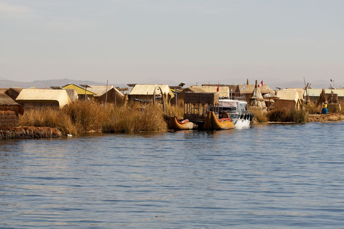Traditional reed houses and totora boats on the Uros floating islands of Lake Titicaca, Peru