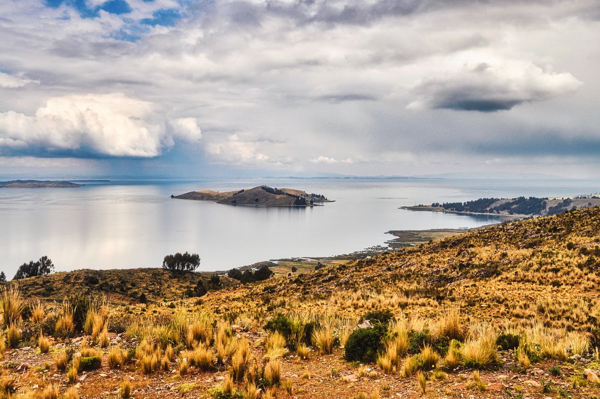 Calm blue waters of Lake Titicaca with distant mountains, Peru