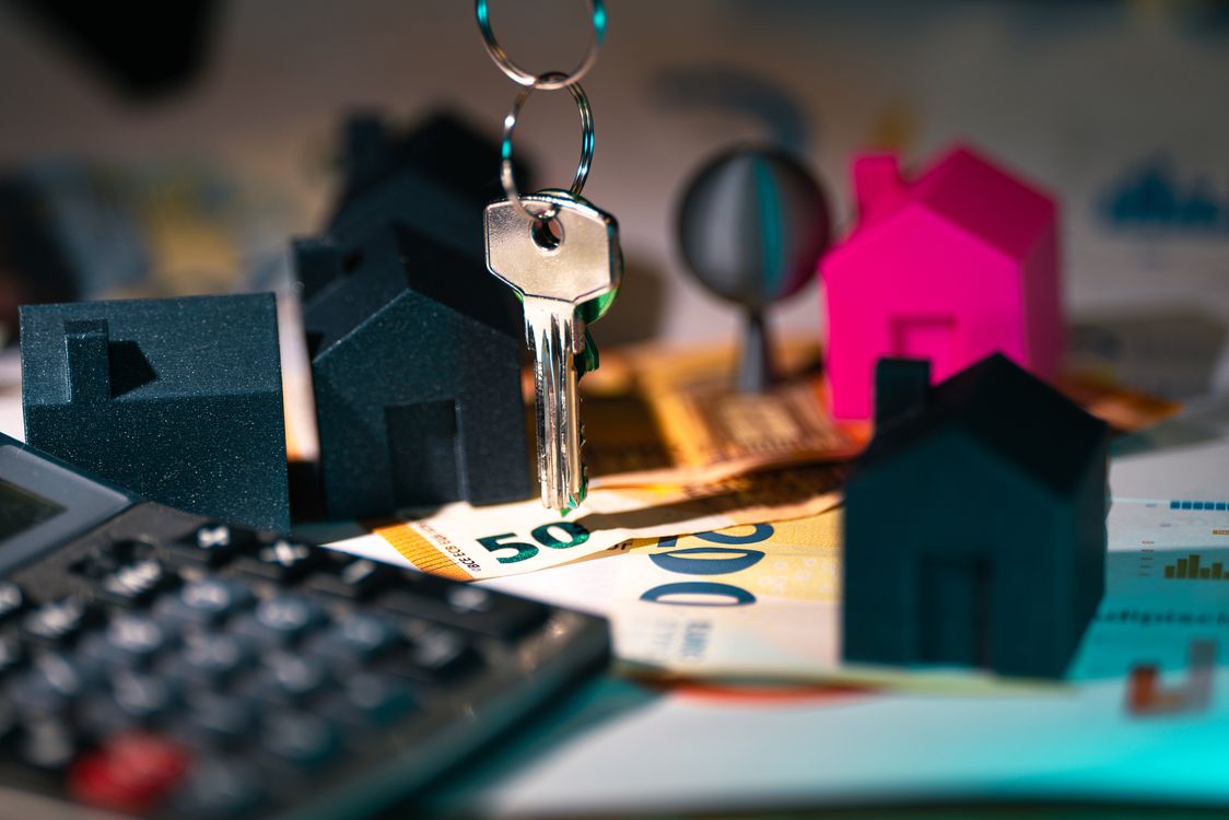 House keys and a miniature home model representing a mortgage in Ghana