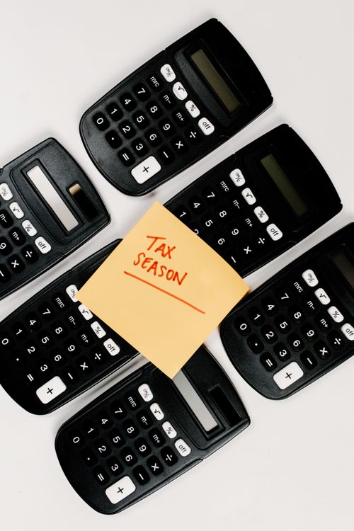 Calculadoras sobre mesa de trabalho contábil com anotações de temporada de impostos