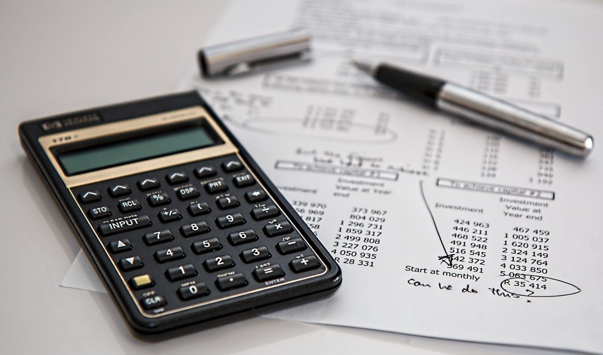Black calculator beside a pen on printed financial statements showing small business accounting calculations