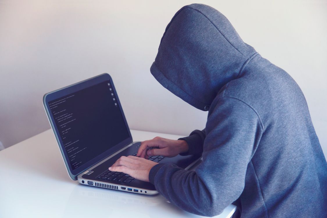 Personne concentrée travaillant sur un ordinateur portable en soirée