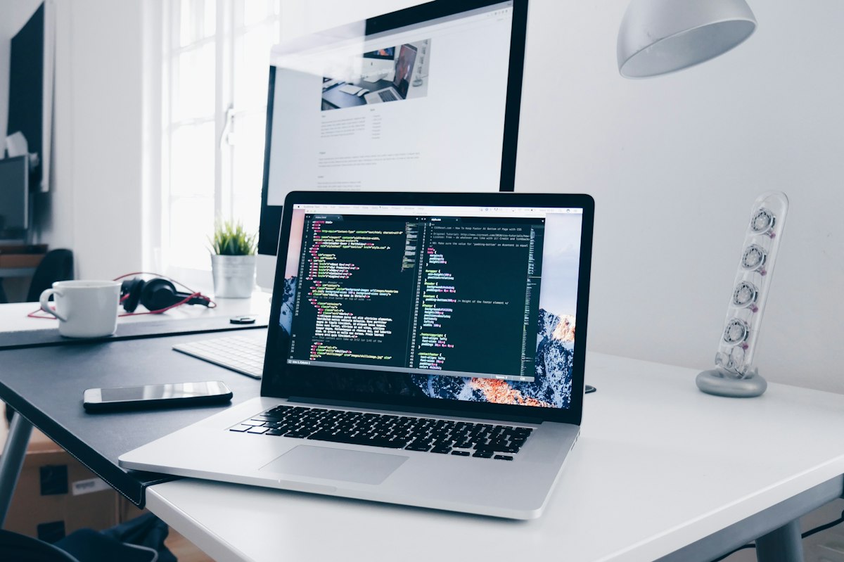 Mains tapant sur un ordinateur portable avec un éditeur de code ouvert