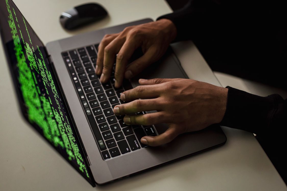 Mains tapant du code de sécurité sur un ordinateur portable le soir